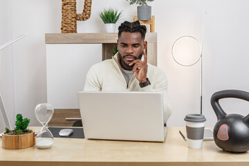 Afro-American man engages in remote work at home office in a cozy and modern environment