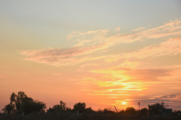 the serene and peaceful moment of sunset. The sun's warm orange and yellow hues spread across the horizon, blending seamlessly into the deep blue sky.