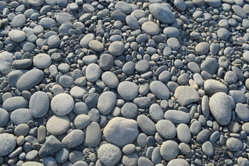 many stones ground off by the water, Milford Sound, Promenade des Anglais in Nice. Popular promenade in the resort town of Pakistan. People are sunbathing on the beach.Smooth stones, pebbles texture