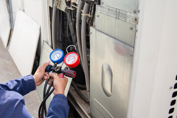 Air conditioner technician checking air conditioner operation	