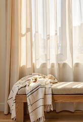 Tranquil wooden bench draped in linen by window, inviting serenity