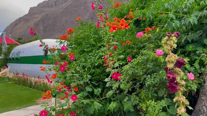 Lush flower bed with colorful blossoms adds charm to repurposed airplane fuselage at Shangrila Resort Hotel Skardu