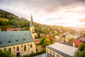The Church of St. Joachim stands proudly in Jachymov, Czechia, surrounded by lush greenery and...