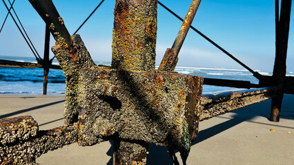 Old rusty metal poles under the old pier facing time and power of nature, sea salty water and strong sun.