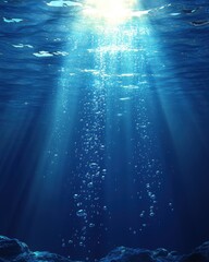 Serene underwater scene featuring sunlight piercing through the ocean's surface illuminating bubbles and rocks