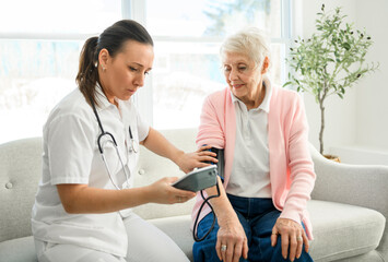 Obraz premium portrait of a young nurse doctor with a senior patient at home during a consultation