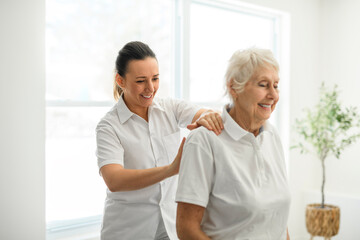 Obraz premium physiotherapist helping senior woman in clinic. Elderly woman undergoing physiotherapy treatment for injury