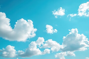 Obraz premium Sunny spring day with fluffy cotton candy clouds floating in a vivid blue sky, perfect for evoking feelings of happiness and tranquility in outdoor photography collections