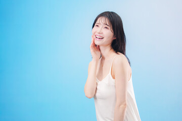 Fototapeta premium 若い女性のビューティーイメージ（水色背景）