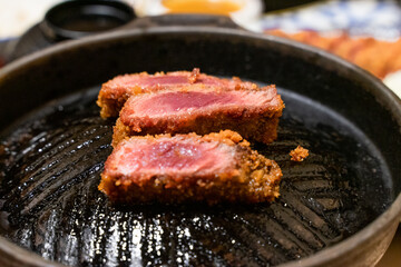 This Japanese-style fried beef steak, known as Gyukatsu, is a mouthwatering dish featuring a perfectly crispy, golden-brown crust with a tender, juicy interior. Cooked to perfection on a sizzling hot 