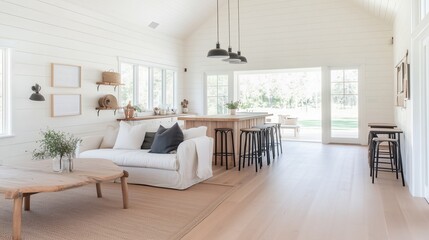 Fototapeta premium A large open living room with a kitchen area. The living room has a couch and a coffee table with a vase of flowers on it. The kitchen has a bar with stools and a dining table