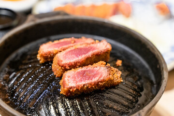 This Japanese-style fried beef steak, known as Gyukatsu, is a mouthwatering dish featuring a perfectly crispy, golden-brown crust with a tender, juicy interior. Cooked to perfection on a sizzling hot 