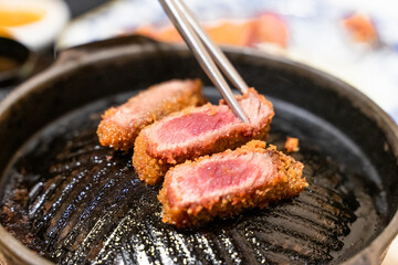 This Japanese-style fried beef steak, known as Gyukatsu, is a mouthwatering dish featuring a perfectly crispy, golden-brown crust with a tender, juicy interior. Cooked to perfection on a sizzling hot 