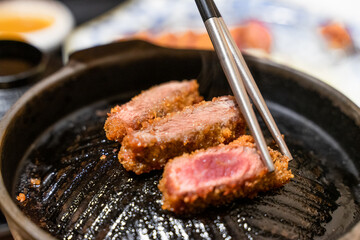 This Japanese-style fried beef steak, known as Gyukatsu, is a mouthwatering dish featuring a perfectly crispy, golden-brown crust with a tender, juicy interior. Cooked to perfection on a sizzling hot 