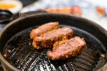 This Japanese-style fried beef steak, known as Gyukatsu, is a mouthwatering dish featuring a perfectly crispy, golden-brown crust with a tender, juicy interior. Cooked to perfection on a sizzling hot 