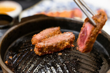 This Japanese-style fried beef steak, known as Gyukatsu, is a mouthwatering dish featuring a perfectly crispy, golden-brown crust with a tender, juicy interior. Cooked to perfection on a sizzling hot 