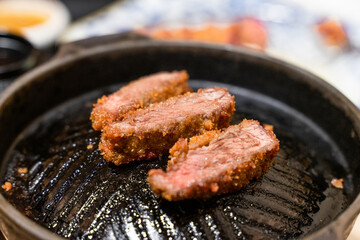 This Japanese-style fried beef steak, known as Gyukatsu, is a mouthwatering dish featuring a perfectly crispy, golden-brown crust with a tender, juicy interior. Cooked to perfection on a sizzling hot 