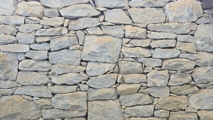 Rough stone wall texture with natural patterns and earthy shades. Ideal for backgrounds, architecture, and rustic designs