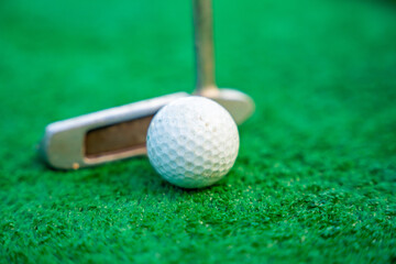 Mini-golf clubs and balls on artificial grass. Family vacations or resort. 