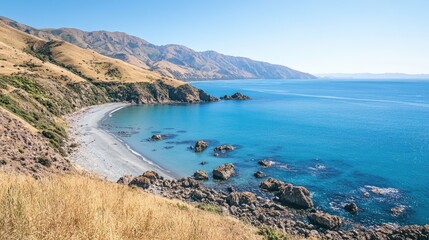 Fototapeta premium A top-down perspective of a secluded bay on New Zealand's coastline, where calm blue waters meet rocky shores.