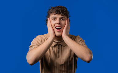 Shocked curly haired man glad, screaming WOW. Impressed guy, unbelievable