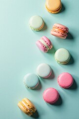 Obraz premium Pastel-colored macarons arranged on a light teal background, a delightful confectionery composition
