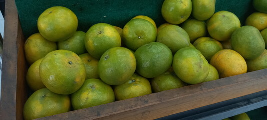 green oranges arranged on a shelf