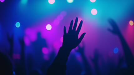 A dimly lit concert or worship event with vibrant stage lighting in blue, purple, and pink tones.