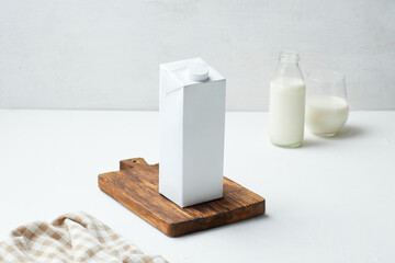 Fresh Milk Carton on Wooden Board With Glass and Bottle of Milk