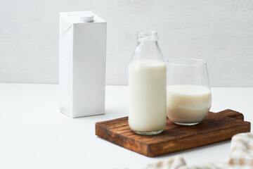 Milk in Glass and Bottle on Wooden Board With Carton in the Background