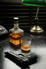 noir vibe set of an old phone, gun  and whisky on table 