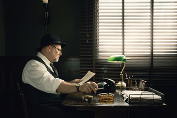 Portrait of detective reading documents in his vintage office