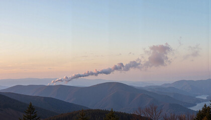 Smoke signals drifting over distant mountains at sunset, communication concept