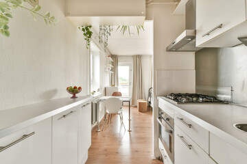 A bright modern kitchen showcasing elegant cabinetry, a cozy dining area, and decorative plants that add a fresh touch to the space.