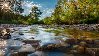 Obraz premium Close-up of a flowing stream with small ripples, high-definition reflections of the sky and trees, water clarity making every submerged pebble visible.