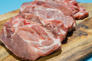 Sliced ​​pork on cutting board on blue table