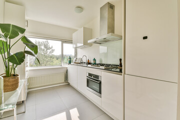 A sleek, modern kitchen featuring minimalist design elements, plants, and large windows allowing natural light, creating a fresh and inviting atmosphere.