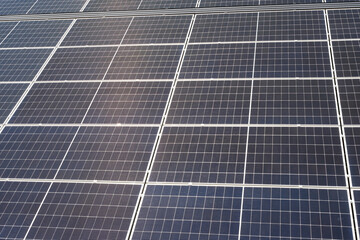 Large array of solar panels reflecting sunlight. Integration of renewable energy technology into modern infrastructure.