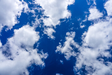 Obraz premium low angle view to a bright blue sky with cumulus clouds