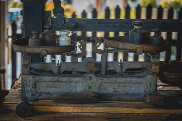 old historical, vintage and antique scale with metal weights lying in an abandoned shed in the countryside