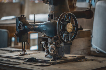 old sewing machine on a tailor's table in an abandoned tailor shop