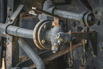 metal wheels and the driving mechanism of an old vintage steam locomotive powered by coal. rusty metal and steel. close-up of mechanics and valves