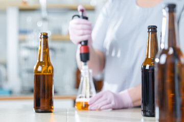 Worker chemist testing beer in laboratory setting