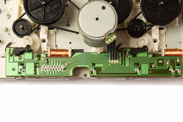 Fototapeta premium Close-up of the magnetic tape drive mechanism of an old double-cassette tape recorder on a white background. Close-up of the magnetic tape drive mechanism. Copy space