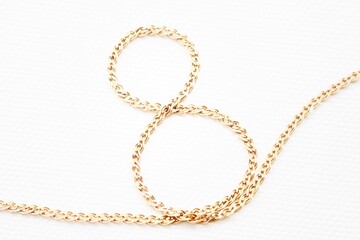 Figure eight made of gold chain isolated on white background.Celebrating International Women's Day. Concept March 8.