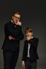 Handsome father and son share a stylish moment in elegant attire at the studio