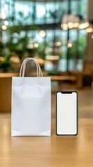 Creative display of a blank smartphone beside an empty shopping bag in a modern, softly lit cafe interior during daytime
