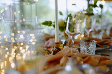 A beautifully arranged table featuring sparkling glassware, soft linens, and glowing lights, ideal for a romantic dinner or festive gathering.