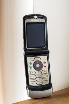 Vintage Motorola Razr V3 flip phone resting on wooden surface