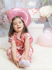 Generated A little girl in pink clothing celebrates in a fairy-tale setting with pastel decorations, a large pink balloon in the shape of a two, and white flowers, radiating joy and innocence.